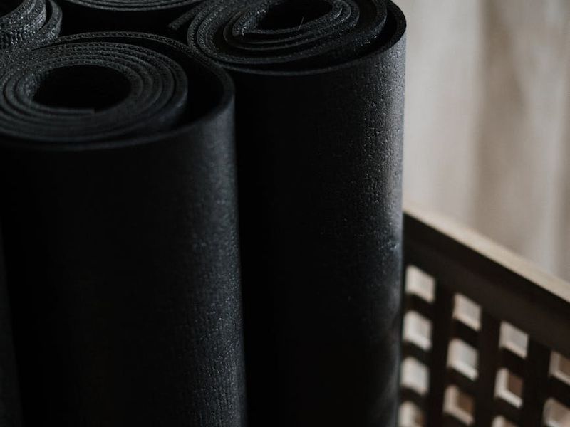 Minimalist exercise space with a black mat and soft lighting